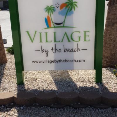 village by the beach sign
